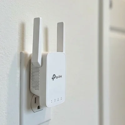 Wi-Fi range extender plugged into an outlet in an interior hallway