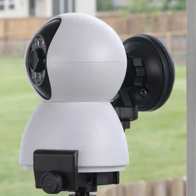 Camera on a suction mount at a window, yard visible beyond